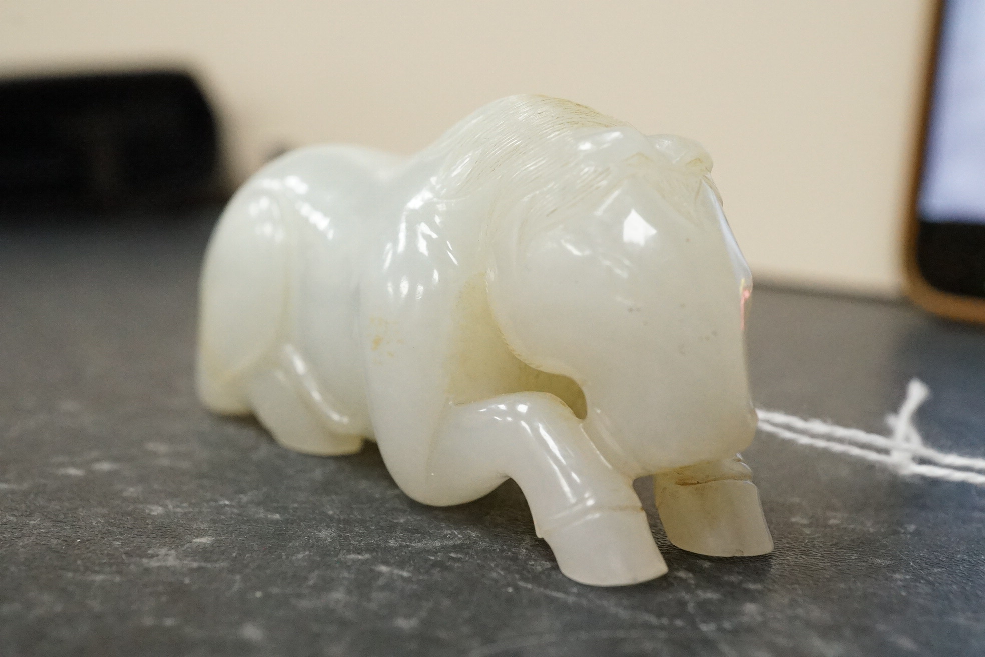 A Chinese white jade figure of a recumbent horse